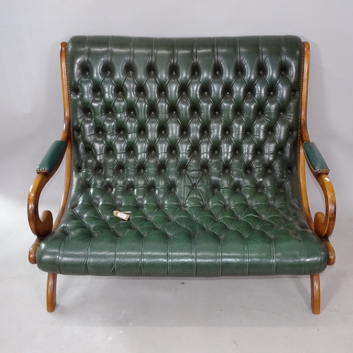 2257 - A studded green leather upholstered 2-seater settee, on X-framed legs, 118cm x 95cm x 90cm