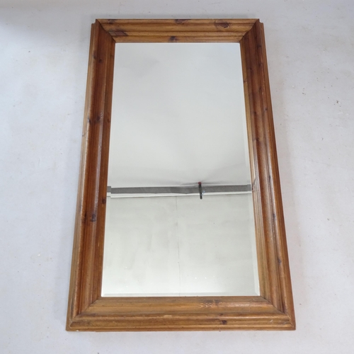 2323 - A modern stained pine-framed bevel-edge wall mirror, 145cm x 83cm