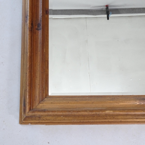 2323 - A modern stained pine-framed bevel-edge wall mirror, 145cm x 83cm