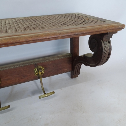 2339 - A carved oak hat and coat rack, with cane panelled top, 151cm