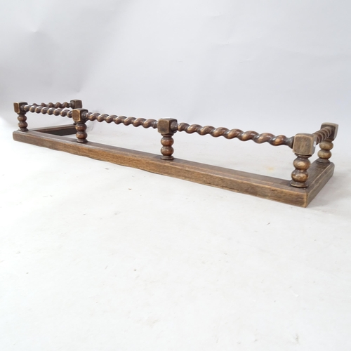 2342 - An early 20th century oak fender, with barley twist rail, 136cm x 18cm x 37cm