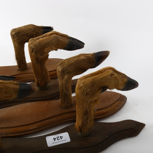 424 - TAXIDERMY - a set of 4 wall-mounted deer-hoof coat hangers, plaque length 40cm