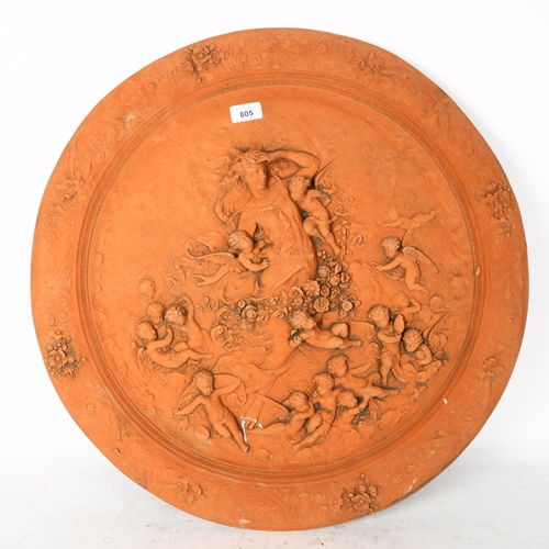 805 - A circular terracotta plaque, with embossed cherub decoration, width 61cm