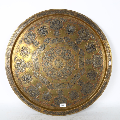 806 - A large Turkish brass charger, with silvered and copper embossed scrolled decoration, and script pan... 