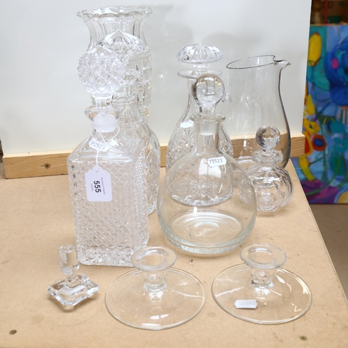 555 - A group of glassware, to include 4 decanters and stoppers, water jug, vase, 2 candle stands etc