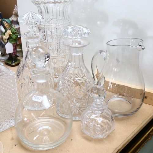 555 - A group of glassware, to include 4 decanters and stoppers, water jug, vase, 2 candle stands etc