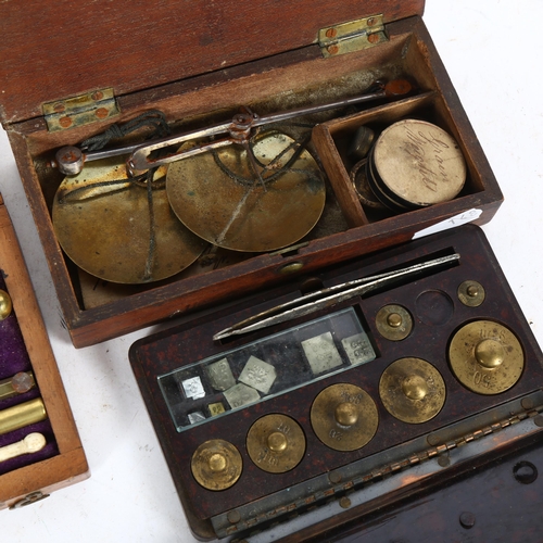 580 - A 19th century mahogany-cased draught set, Bakelite-cased weights, and 2 sets of small balance scale... 