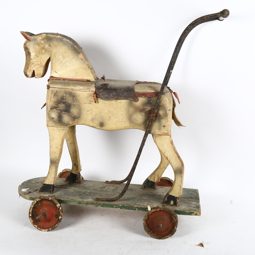 634 - A child's Vintage painted push-along toy horse, length 60cm