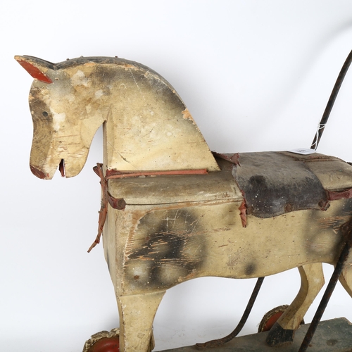 634 - A child's Vintage painted push-along toy horse, length 60cm