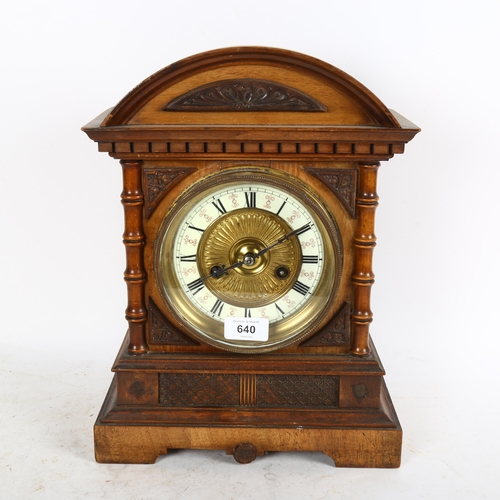 640 - An early 20th century carved walnut-cased 8-day mantel clock with enamel dial, height 36cm