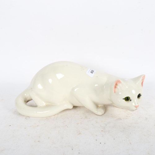 656 - Just Cats, a prowling white ceramic cat with glass eyes, with black back stamp under, length 35cm