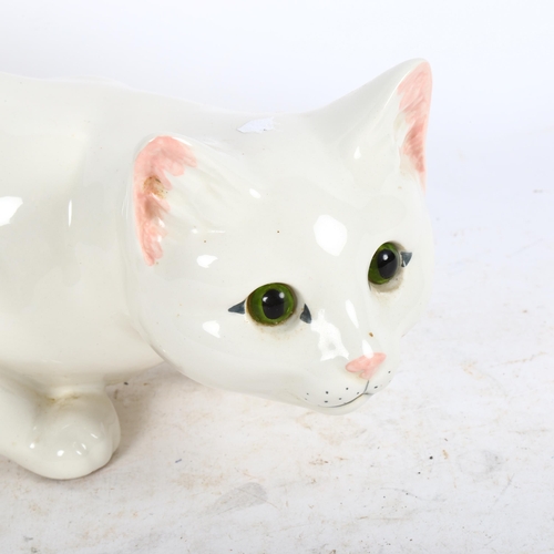 656 - Just Cats, a prowling white ceramic cat with glass eyes, with black back stamp under, length 35cm