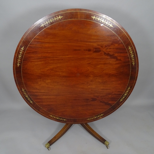 2510 - A crossbanded mahogany and brass inlaid circular tilt-top dining table, 130cm x 76cm