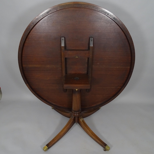 2510 - A crossbanded mahogany and brass inlaid circular tilt-top dining table, 130cm x 76cm