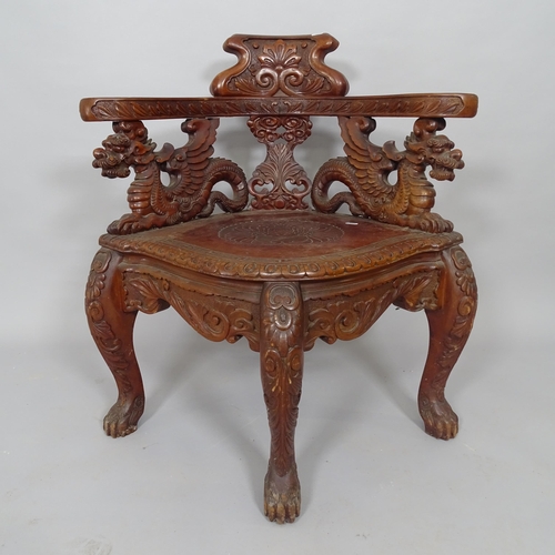 2513 - An Oriental hardwood corner armchair, with carved dragon decoration