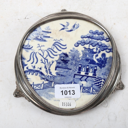 1013 - A silver plated teapot stand, on cast scrolled feet, with inset Willow pattern plaque