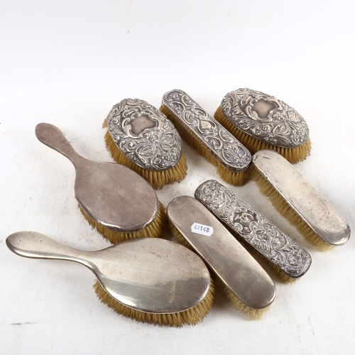 1091 - A set of 4 early 20th century silver-backed dressing table brushes, and another set of silver-backed... 