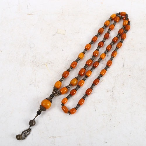 1120 - A long amber bead prayer necklace, length 61cm