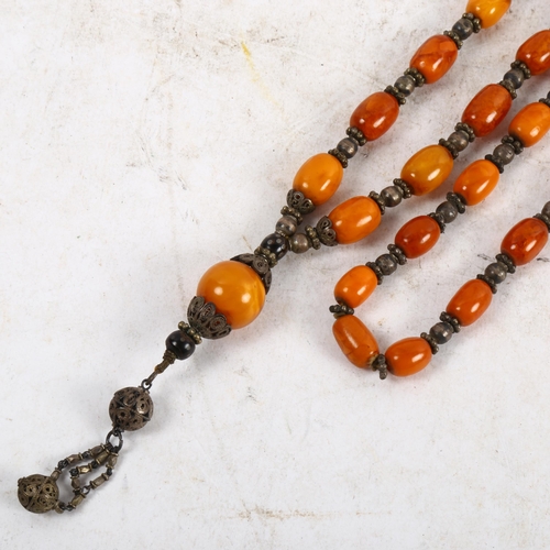 1120 - A long amber bead prayer necklace, length 61cm