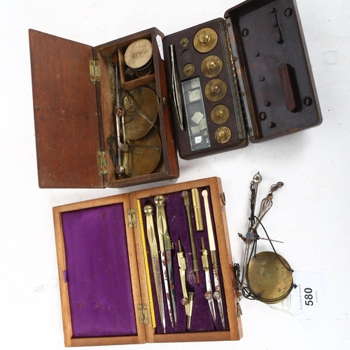 580 - A 19th century mahogany-cased draught set, Bakelite-cased weights, and 2 sets of small balance scale... 