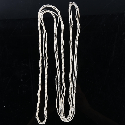 151 - A long triple-strand seed pearl torsade necklace, with unmarked white metal old-cut diamond set clas... 