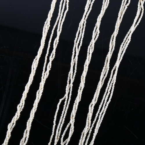 151 - A long triple-strand seed pearl torsade necklace, with unmarked white metal old-cut diamond set clas... 