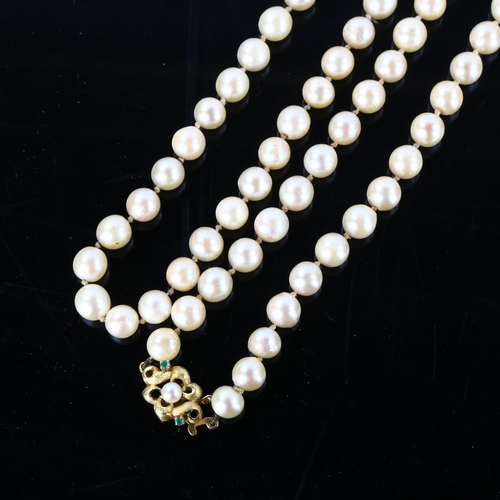 153 - A long single-strand cultured pearl necklace, with unmarked gold pearl and emerald textured clasp, n... 