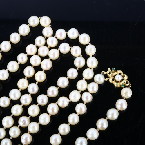 153 - A long single-strand cultured pearl necklace, with unmarked gold pearl and emerald textured clasp, n... 