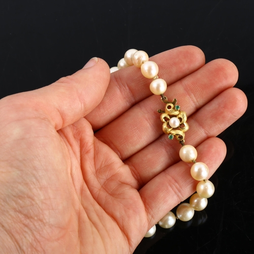 153 - A long single-strand cultured pearl necklace, with unmarked gold pearl and emerald textured clasp, n... 