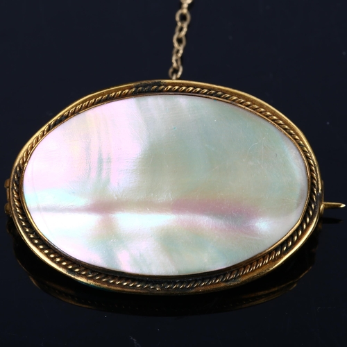 190 - A Victorian oval mother-of-pearl panel brooch, unmarked yellow metal settings with rope twist surrou... 