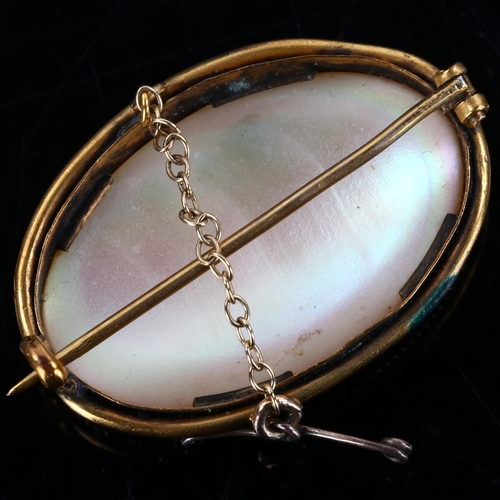 190 - A Victorian oval mother-of-pearl panel brooch, unmarked yellow metal settings with rope twist surrou... 