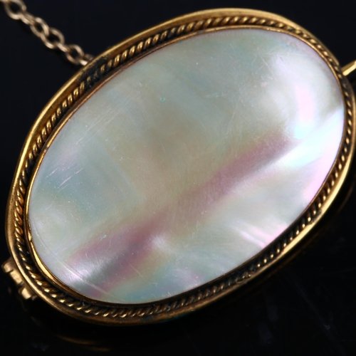 190 - A Victorian oval mother-of-pearl panel brooch, unmarked yellow metal settings with rope twist surrou... 