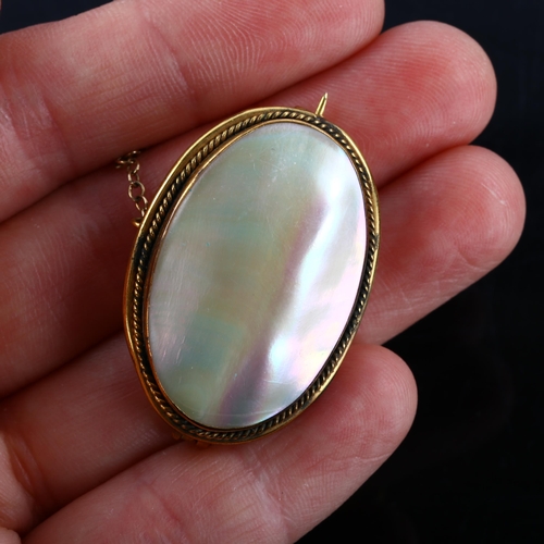 190 - A Victorian oval mother-of-pearl panel brooch, unmarked yellow metal settings with rope twist surrou... 