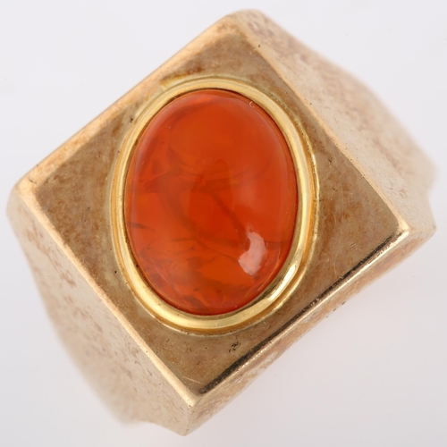 193 - A late 20th century fire opal signet ring, heavy unmarked gold settings with oval cabochon fire opal... 