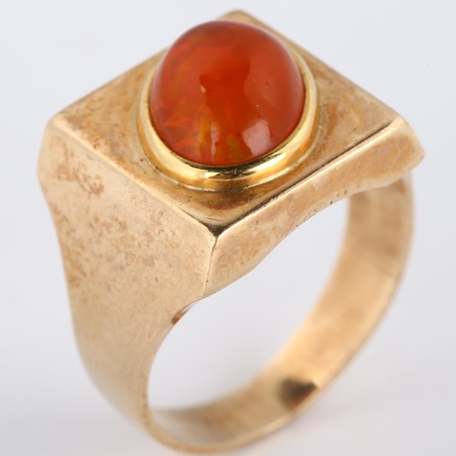 193 - A late 20th century fire opal signet ring, heavy unmarked gold settings with oval cabochon fire opal... 