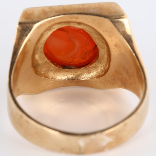 193 - A late 20th century fire opal signet ring, heavy unmarked gold settings with oval cabochon fire opal... 