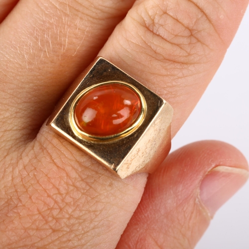 193 - A late 20th century fire opal signet ring, heavy unmarked gold settings with oval cabochon fire opal... 