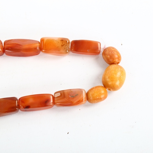 207 - A carnelian and butterscotch amber bead necklace, largest amber bead length 21.4mm, necklace length ... 