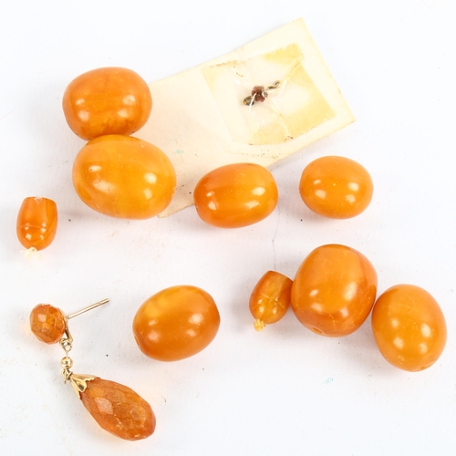 210 - A group of unmounted butterscotch amber beads, largest length 23.9mm, 25.8g, and an amber drop earri... 