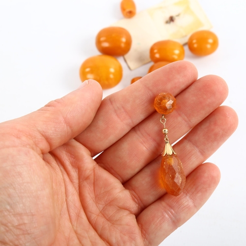 210 - A group of unmounted butterscotch amber beads, largest length 23.9mm, 25.8g, and an amber drop earri... 