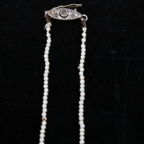 226 - A fine graduated single-strand seed pearl necklace, with unmarked white metal diamond set clasp, pea... 