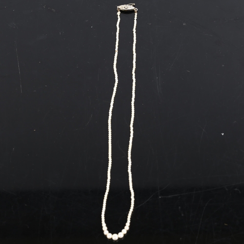 226 - A fine graduated single-strand seed pearl necklace, with unmarked white metal diamond set clasp, pea... 