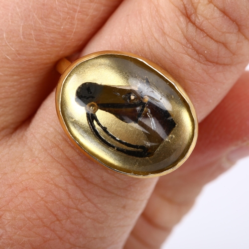 266 - An Essex Crystal style reverse painted horse-head ring, unmarked silver-gilt settings, setting heigh... 