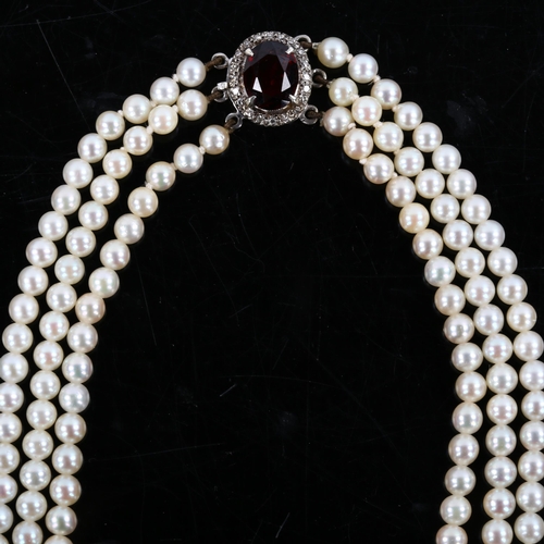 283 - A Vintage triple-strand pearl necklace, with unmarked white metal garnet and diamond cluster clasp, ... 