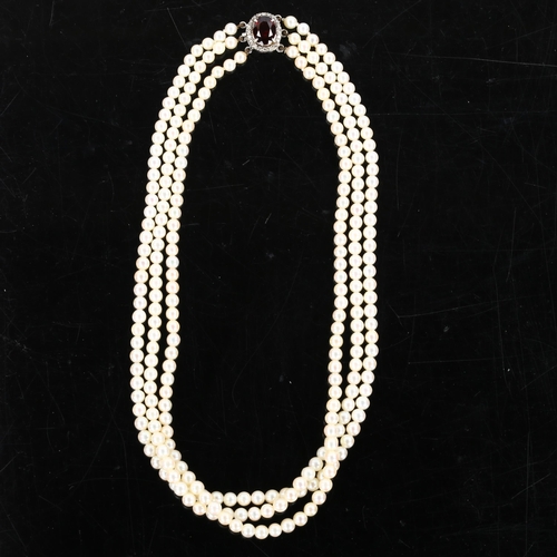 283 - A Vintage triple-strand pearl necklace, with unmarked white metal garnet and diamond cluster clasp, ... 