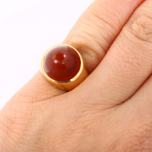 308 - A Continental carnelian dress ring, gold settings with round high cabochon carnelian, setting height... 