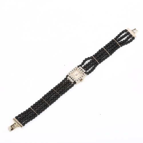 19 - EXQUISIT - a lady's 18ct white gold diamond and jet mechanical cocktail bracelet watch, circa 1960s,... 