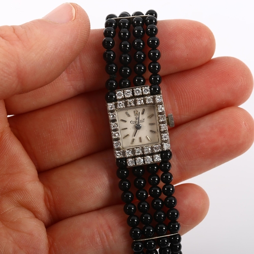 19 - EXQUISIT - a lady's 18ct white gold diamond and jet mechanical cocktail bracelet watch, circa 1960s,... 