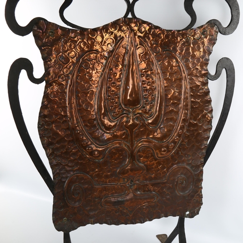 1064 - An Arts and Crafts wrought-iron and copper fire screen, with embossed panel, unsigned, height 78cm