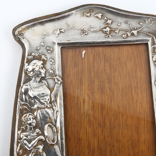 1085 - An Art Nouveau electroplate photo frame, relief moulded decoration depicting a woman and child, oak ... 